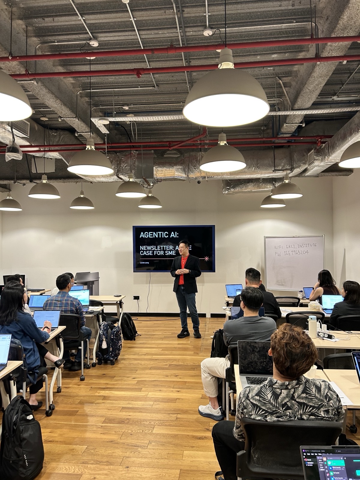 A full room of working professionals with laptops at AI Power Users Meetup 01