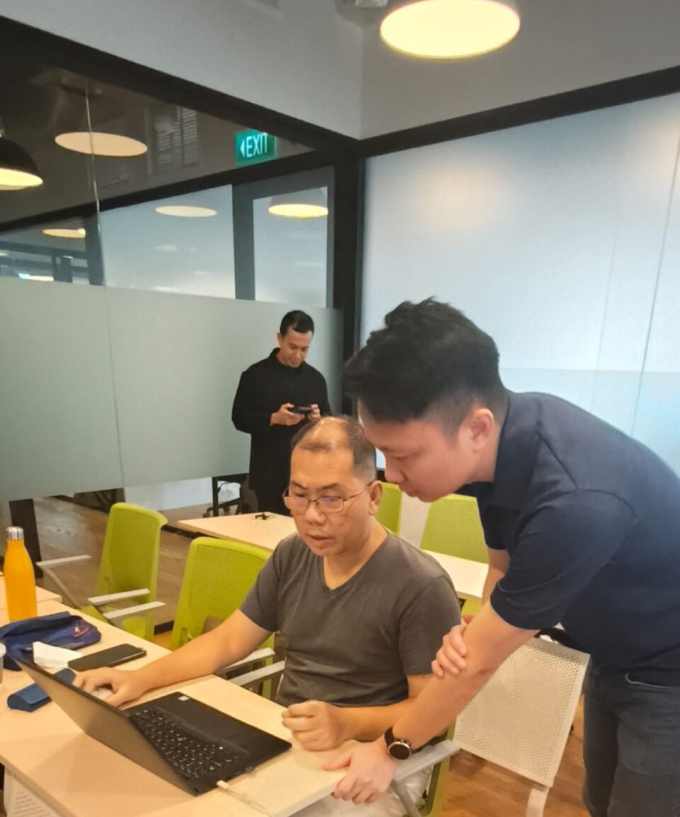 Keith Teo helping a participant build their site at a Claude Code workshop in Singapore